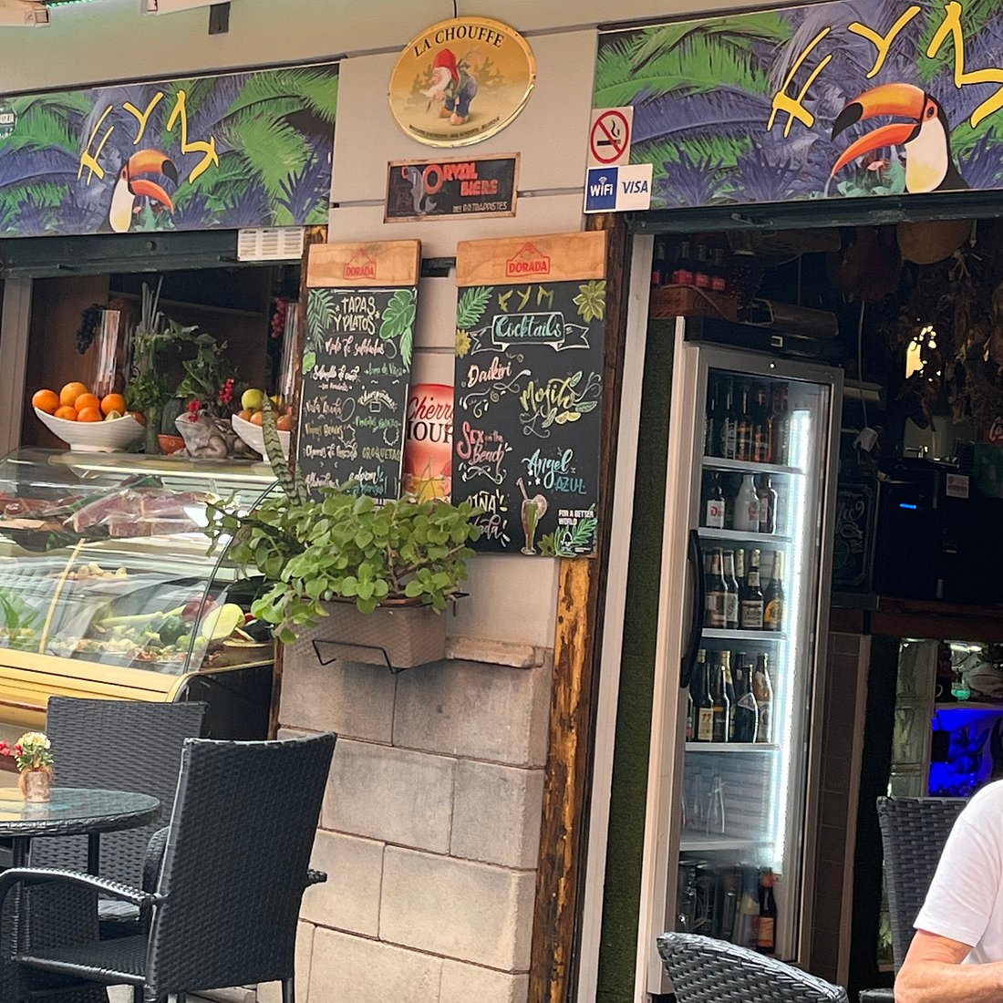 Entrada de F & M, con las pizarras de tapas y cócteles, la nevera de cervezas de importación y la terraza del callejón